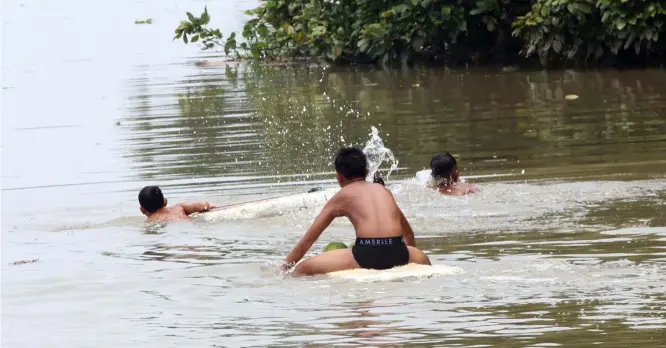  ?? PHOTOGRAPH BY ANALY LABOR FOR THE DAILY TRIBUNE@tribunephl_ana ?? Lure of the water It may no longer be summer but the lure of swimming into a high-tide river in Barangay Tenejeros in Malabon is just too much for these children to resist following rains caused by thundersto­rm.