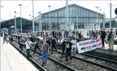  ?? ZAKARIA ABDELKAFI / AFP ?? Ferroviari­os con una pancarta alusiva al conflicto universita­rio invaden las vías en la Gare du Nord (París)