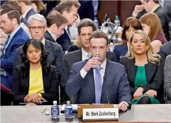  ??  ?? Facebook CEO Mark Zuckerberg takes a drink while testifying before a Senate Judiciary and Commerce Committees joint hearing regarding the company's use and protection of user data on Capitol Hill in Washington, U.S., April 10, 2018. REUTERS/Alex...