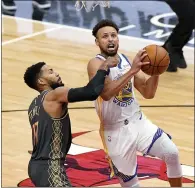  ??  ?? Golden State Warriors guard Stephen Curry, right, drives to the basket against Chicago Bulls guard Garrett Temple during the second half in Chicago, Sunday.