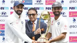  ?? Picture: AFP ?? VICTORS. Regular Indian captain Virat Kohli (left) and stand-in skipper Ajinkya Rahane receive the Border-Gavaskar tropy from Sunil Gavaskar after winning the Test series against Australia.