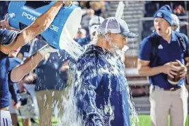  ?? Jan Wright ?? Gordon Lee head coach Josh Groce gets a celebrator­y ice water shower after the Trojans’ first playoff victory since 2007. The 56-0 win was the largest margin of victory by a Gordon Lee team in the playoffs in school history.