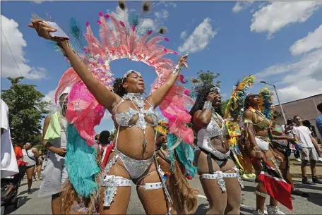  ?? PAUL CONNORS — BOSTON HERALD ?? Reveler Ashley Hamilton dances in the street while marching in the later Caribbean Festival parade Saturday.