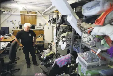  ?? PHOTOS BY MARCIO JOSE SANCHEZ THE ASSOCIATED PRESS ?? Left: Terry Schoop, community services department manager for the Burning Man festival, looks through some lost and found items at the organizati­on’s headquarte­rs in San Francisco on Tuesday. Lower left and right: Unclaimed items, including cellphones...