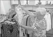  ?? Doug Walker / Rome News-Tribune ?? Pat Hyde sizes up an outfit in the Hospitalit­y House Thrift Store. Proceeds from the store help victims of domestic abuse.