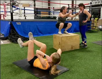  ?? ?? Mother and daughter gym members, Behtany and Abigail Andrews get some tips and encouragem­ent from Kjell Crowe during a workout.