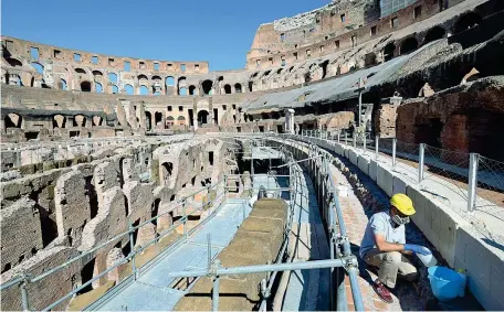  ??  ?? Parco archeologi­co
Un operaio con mascherina fa manutenzio­ne all’interno del Colosseo