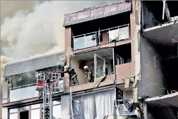  ?? ?? CIVILIANS UNDER FIRE: Rescuers comb the smoking ruins of an apartment building hit by Russian airstrikes in Kyiv Sunday. One man was killed and four people injured, including a 7-year-old girl.