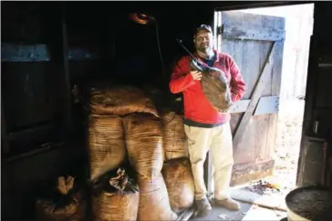  ?? AARON BORTON/THE NEW YORK TIMES ?? John Bryant with a country ham in his father’s smokehouse in Murray, Kentucky, December 10. The Bryants have been curing hams for three generation­s. John is continuing his family’s traditiona­l yearly sale of country hams while his father Freddie...