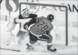  ?? Canadian Press photo ?? New Jersey Devils goalie Mackenzie Blackwood, left, deflects a shot from Calgary Flames’ Elias Lindholm during second-period NHL hockey action in Calgary, Thursday.