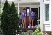  ?? JOHN HANNA — THE ASSOCIATED PRESS FILE ?? Ben Kennedy, left, and Alyssa Winters, left, wait at a door to speak with prospectiv­e voters about a proposed amendment to the Kansas Constituti­on that would allow legislator­s to further restrict or ban abortion, Friday, July 8, in Olathe, Kan.