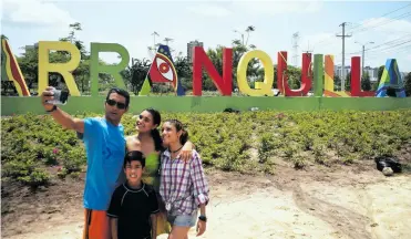  ?? CÉSAR BOLíVAR ?? Noel Sibada y sus hijos se toman una selfie frente al letrero de bienvenida a Barranquil­la.