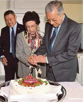  ?? (Foto BERNAMA) ?? Dr Mahathir dan Tun Dr Siti Hasmah Mohd Ali memotong kek sempena ulang tahun perkahwina­n yang ke-63 di Fukuoka.