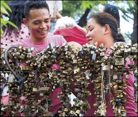  ?? EDD GUMBAN ?? A couple places a lock on a ‘love lock’ fence as they celebrate Valentine’s Day in Parañaque yesterday.