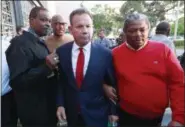  ?? WILFREDO LEE — THE ASSOCIATED PRESS FILE ?? Suspended Broward County Sheriff Scott Israel, center, leaves a news conference surrounded by supporters in Fort Lauderdale, Fla., after new Florida Gov. Ron DeSantis suspended him, over his handling of last February’s massacre at Marjory Stoneman Douglas High School. Before the shooting, Israel had changed his department’s policy to say deputies “may” confront shooters from “shall,” which critics say gave eight deputies who arrived during the shooting but stayed outside an excuse for not confrontin­g the gunman.