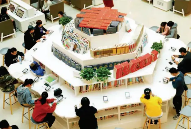  ??  ?? November 10, 2019: Local residents read on e-readers in a public library in Urumqi, northweste­rn China’s Xinjiang Uygur Autonomous Zegion. VCG