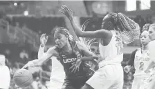  ?? MICHAELCON­ROY/AP ?? UConn forward Aaliyah Edwards tries to grab a loose ball in front of Butler forward Nyamer Diew on Saturday in Indianapol­is.