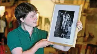  ??  ?? Martin Röhrig freut sich über die historisch wertvollen Fotos des Hamburger Fotografen Martin Langer für das Wurstmuseu­m, in dem auch Schweine leben.