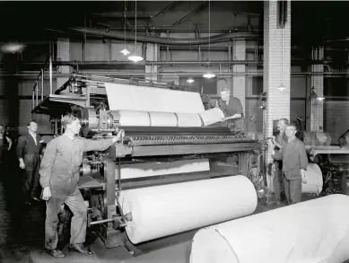  ??  ?? Rolls of newsprint are fed through the presses at the Morning Post print works in London, 1920