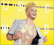  ?? Frazer Harrison Getty Images ?? FRANKIE GRANDE goes for the gold. The gilded chest was paired with a crystal-embroidere­d silver suit and rainbow hair.