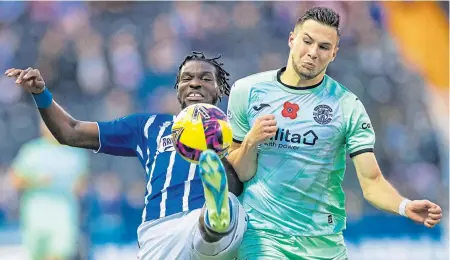  ?? ?? Killie’s Jeriel Dorsett wins the ball from Hibs’ Mykola Kukharevyc­h