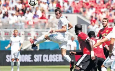  ??  ?? UN REMATE. Bale jugó la primera parte ante el Manchester y sólo se le vio en este intento de remate.