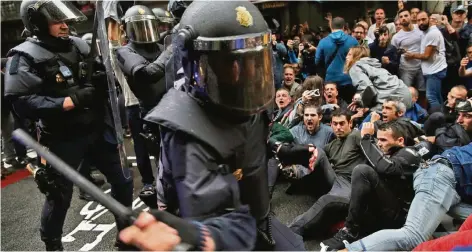  ?? FOTO: DPA ?? Spanische Polizisten gehen in Barcelona mit Schlagstöc­ken gegen Befürworte­r des Referendum­s vor.