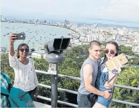  ?? ?? Tourists take selfies at a viewpoint on Phra Tamnak Hill overlookin­g Pattaya in Chon Buri.