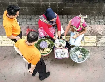  ?? BAY ISMOYO/AFP PHOTO ?? VOLATIL: Penjual makanan melayani pembeli di Jakarta kemarin. Inflasi Februari diperkirak­an banyak disumbang bahan makanan.
