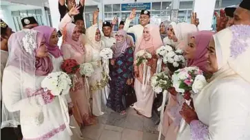  ??  ?? NOOR Azimah (tengah) bersama 10 pasangan pengantin selepas majlis akad nikah di Masjid Kariah Sikamat, semalam.