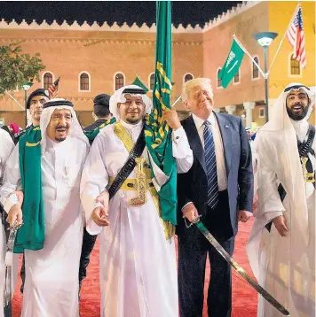  ??  ?? Saudi Arabia’s King Salman bin Abdulaziz Al Saud, left, invites Donald Trump to take part in a sword dance during his stay in Riyadh