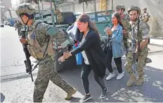  ?? AP ?? Special forces soldiers assist teachers as they flee their school during the gunfire in Beirut’s Ain Al Remmaneh neighbourh­ood.