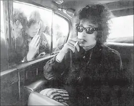  ?? Barry Feinstein Photograph­y ?? BOB DYLAN in the back of a limousine in London in 1965, seemingly oblivious to fans just outside from “Dont Look Back,” released two years later.