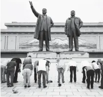  ?? AFP PHOTO ?? A group of Western tourists bow deeply before the statues of North Korea’s founder Kim Il-sung (left) and his son and successor, Kim Jong-il, in Pyongyang on Sunday, a ritual that the US intends to stop its citizens performing as Washington is due to...