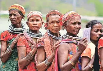  ?? Reuters ?? ODISHA: Women from the Bonda tribe wait to vote in Malkangiri district on Monday.