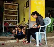  ?? PHOTOS BY LAUREN DECICCA / THE NEW YORK TIMES ?? Norazila, 14, checks her phone at the entrance of her family’s restaurant in Gua Musang, Malaysia.