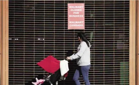  ??  ?? LOS ANGELS: A woman walks past a recently shuttered Walmart store in Chinatown that is part of the closure of 154 store locations across the United States, in Los Angeles yesterday.— AFP