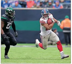  ?? [THE ASSOCIATED PRESS] ?? Giants running back Saquon Barkley runs past Jets linebacker Brandon Copeland during the Nov. 10 game in East Rutherford, N.J.