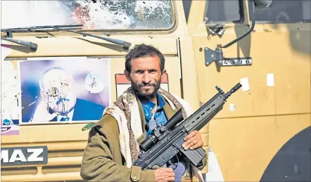  ?? [ AFP ] ?? Ali Abdullah Saleh als Zielscheib­e. Ein Houthi-Kämpfer posiert vor einem durchlöche­rten Foto des Ex-Diktators.