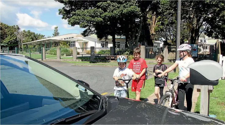  ?? YVETTE BATTEN/FAIRFAX NZ ?? Welbourn School pupils, from left, Patrick Bull, Olly Foy, Taylor Wyatt and Charlotte Bull, prepare to go around a car parked across the footpath.