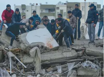  ?? KHALIL HAMRA/AP ?? Locals do what they can to search for earthquake survivors amid the rubble Monday in Adana, Turkey.