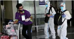  ??  ?? Passengers wearing personal protective suits walk to the check-in area at the internatio­nal airport in Manila yesterday for their commercial flight to the Chinese city of Guangzhou.