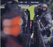  ?? PETER BYRNE / PA ?? An armed police officer holds a breaching shotgun, used to blast the hinges off a door after an explosion at the Liverpool Women’s Hospital in Liverpool, England, Monday.