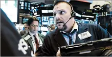  ?? RICHARD DREW/AP ?? Trader Michael Milano, right, works on the floor of the New York Stock Exchange. Equities shed 4 percent of value in a week.