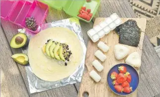  ??  ?? CHEFS QUINN and Karen Hatfield pack their kids a vegetarian burrito made with rice, black beans, cheese and avocado, along with rice and tuna salad molds, seaweed and fruit.