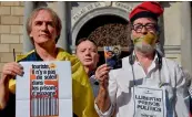  ??  ?? A man (right) shows a picture of two leaders of Catalan separatist groups, Jordi Sanchez and Jordi Cuixart, who were detained for sedition, as he protests demanding their freedom at ‘Generalita­t’ palace in Barcelona on Monday. —