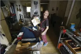  ??  ?? Pat King shows a Gibson Explorer guitar in a book on Gibson guitars next to a copy of one he is working on.