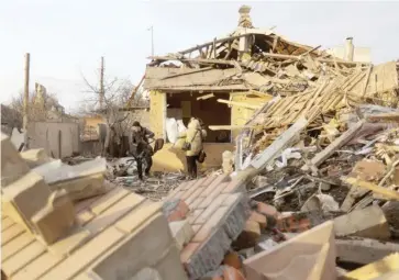  ?? ANATOLII STEPANOV/AGENCE FRANCE-PRESSE ?? LOCAL residents carry out belongings from a house destroyed by a Russian missile in Chuhuyiv, Kharkiv region, eastern Ukraine.
