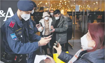  ?? REUTERS ?? Policías verifican el estatus de vacunación de compradore­s en una tienda de Viena, Austria