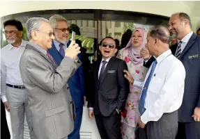  ??  ?? Dr Mahathir (left) takes a photo of cabinet ministers. — Bernama photos